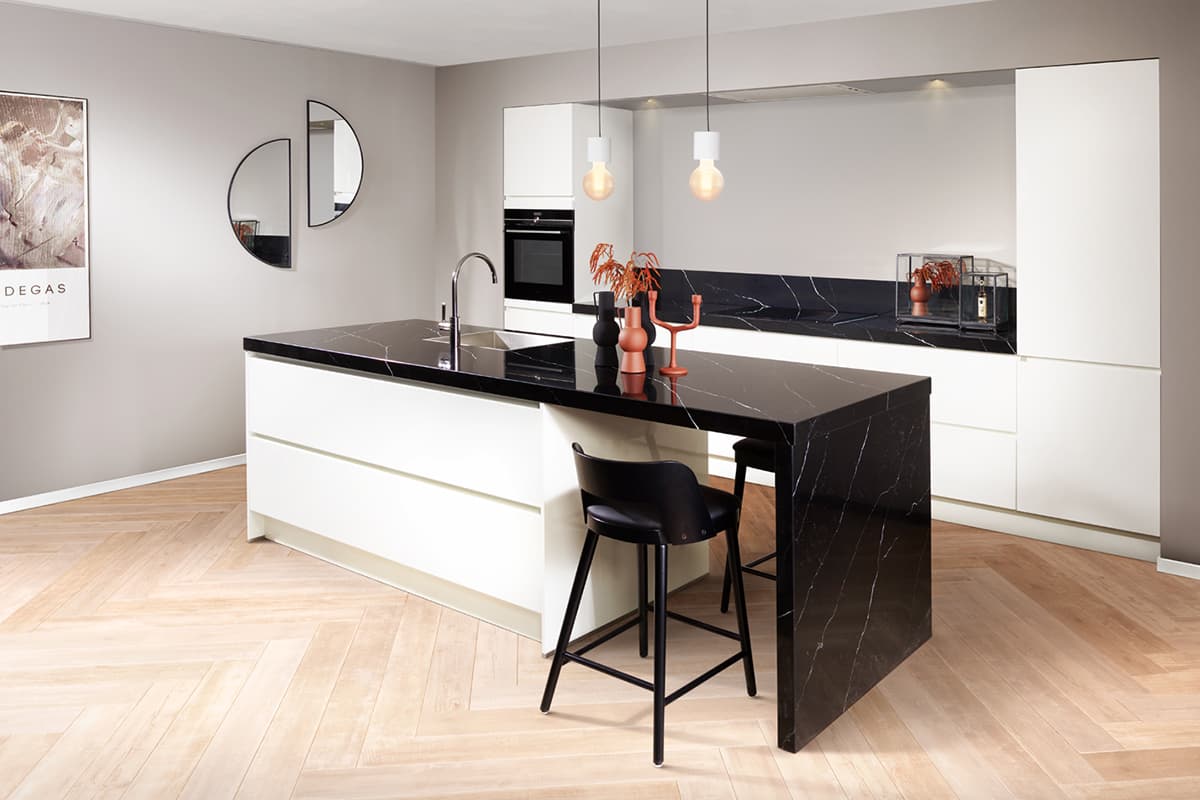 Moderne witte eilandkeuken met zwart werkblad
